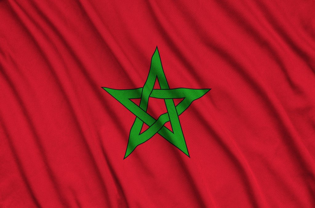 Morocco flag  is depicted on a sports cloth fabric with many folds. Sport team waving banner